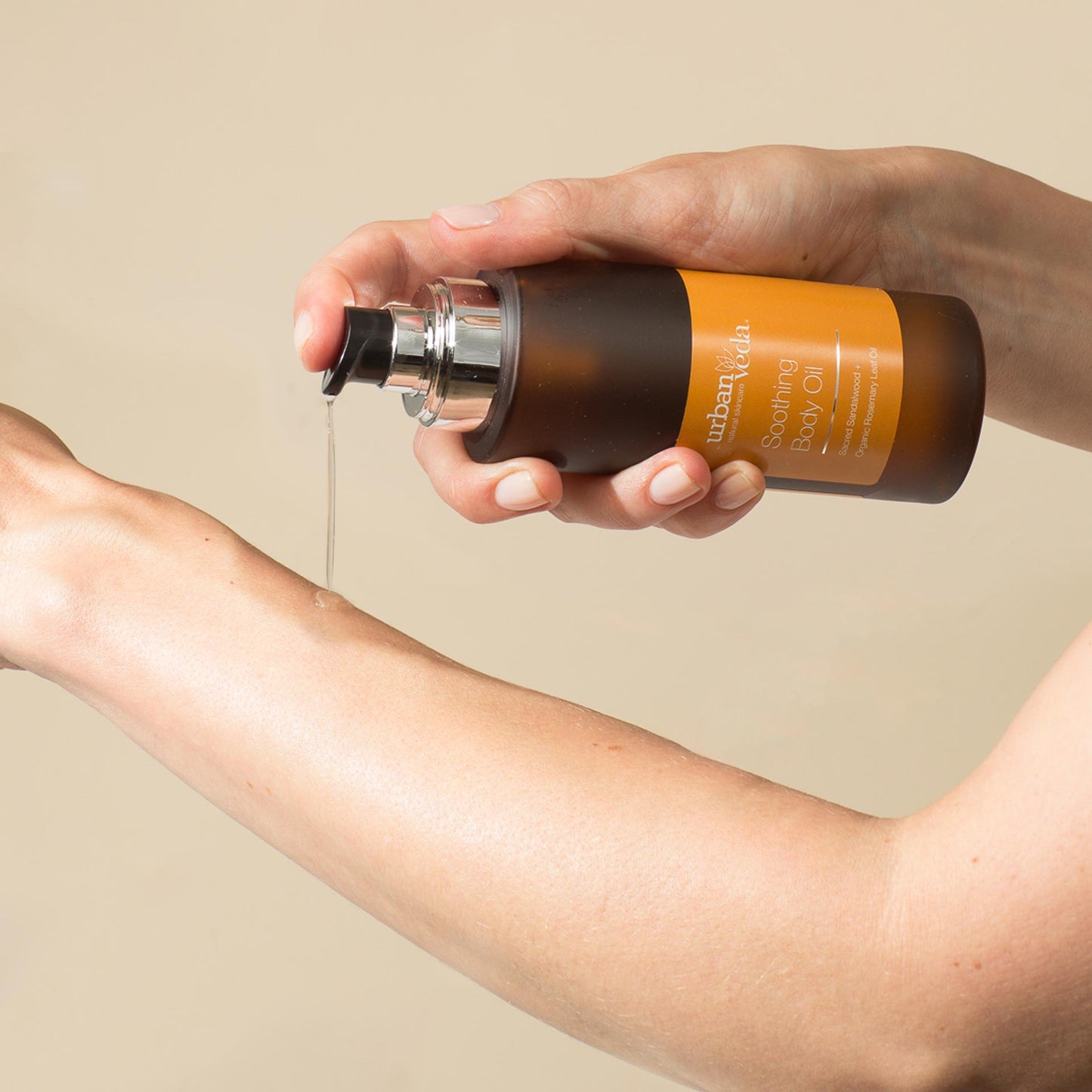 Sandalwood body oil poured onto a hand for massage - urban veda