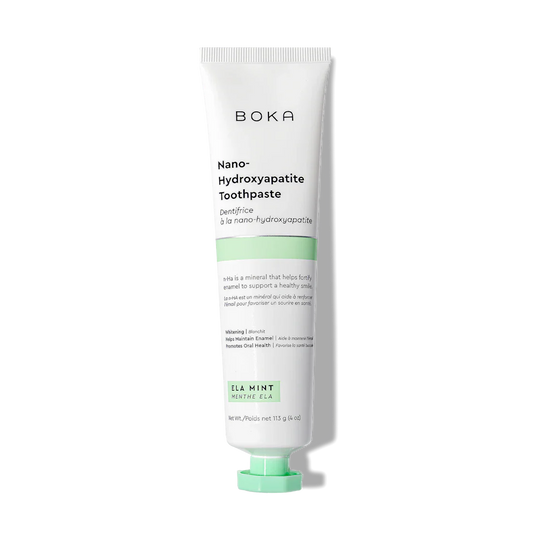 A white tube of Ela Mint n-Ha Toothpaste, fluoride-free with a green label and mint flavor.