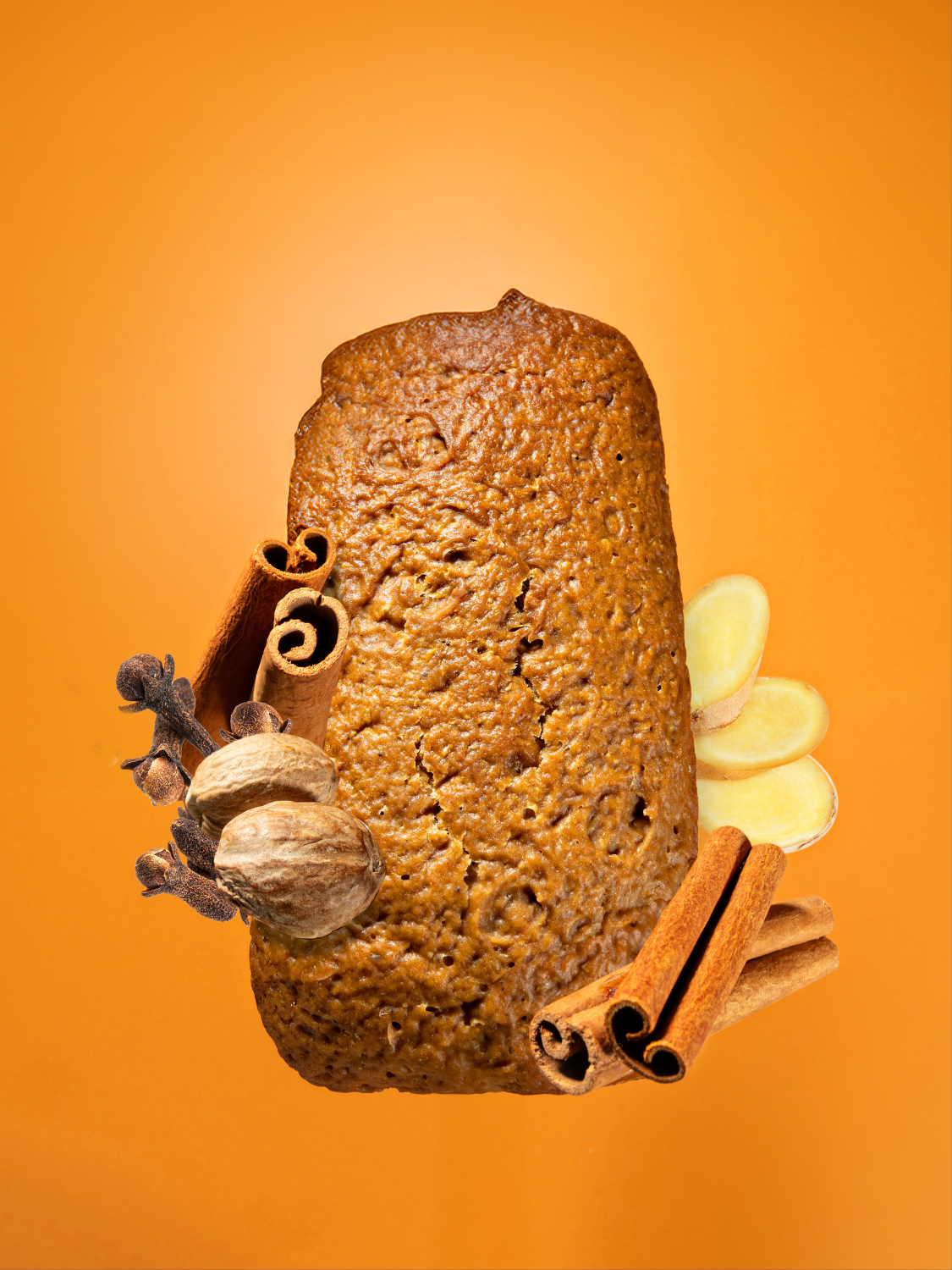 Pumpkin Spice Loaf with Ingredients (cinnamon, ginger, clove, nutmeg) on an orange background.