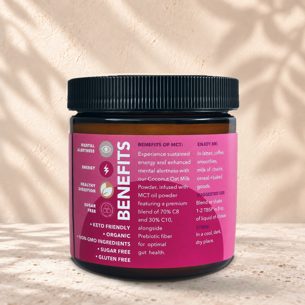 Back of the Eleven TLC Coconut Oat MCT Creamer 200g amber glass jar on a travertine ledge against a warm plaster wall.